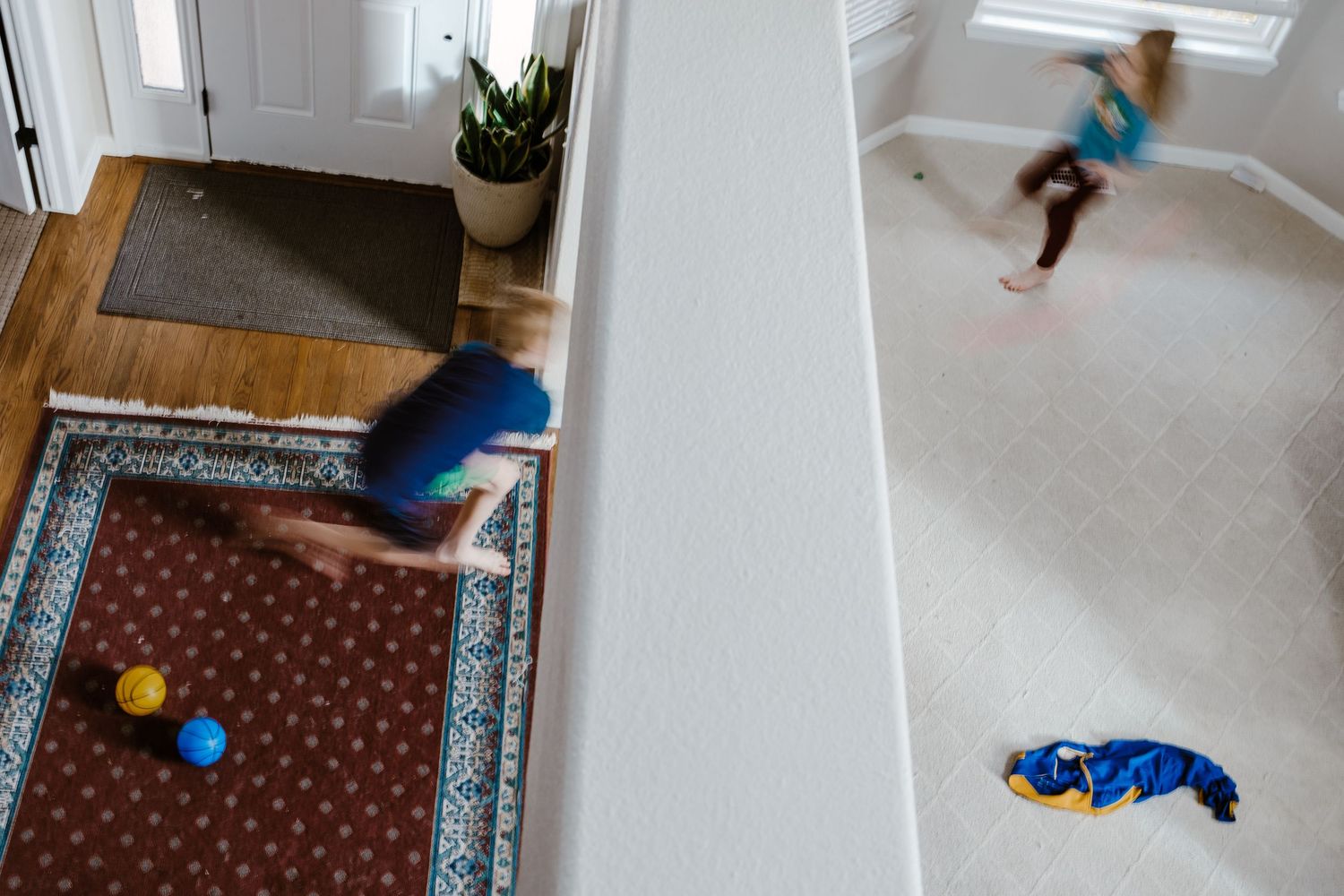 Children running and playing in living room, blurred movement.