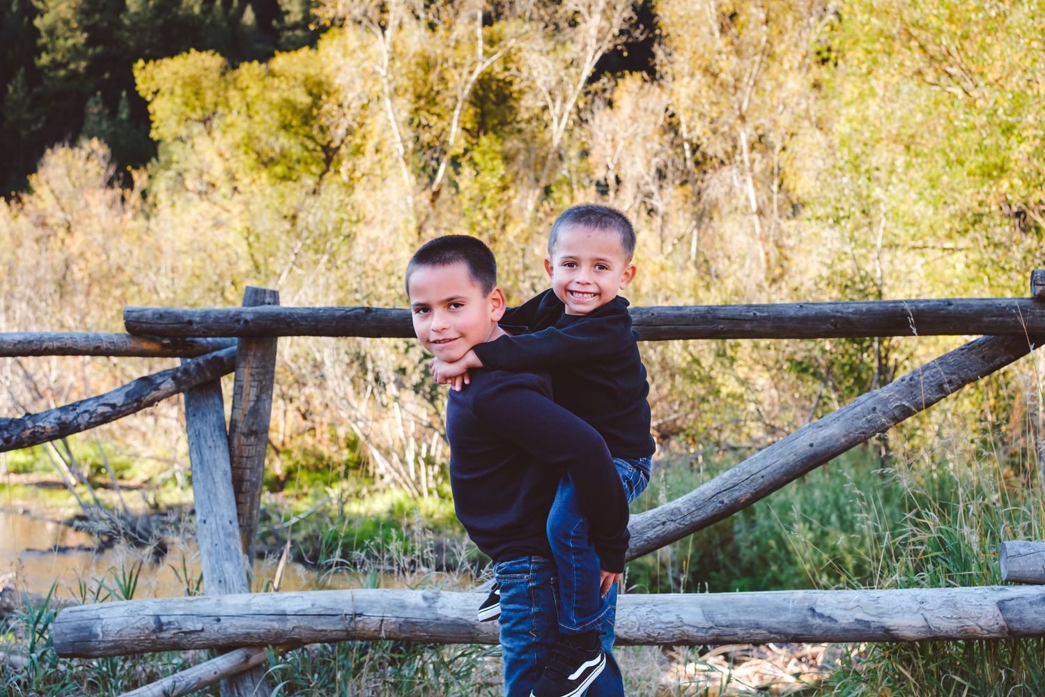 Older brother giving younger brother a piggy back ride.