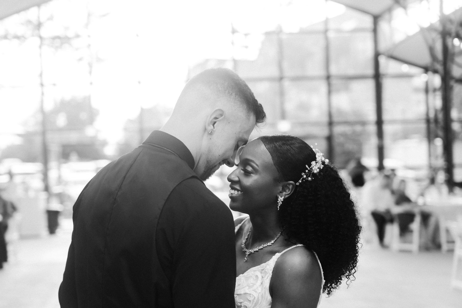 Intimate black and white portrait of newlyweds sharing a tender moment.
