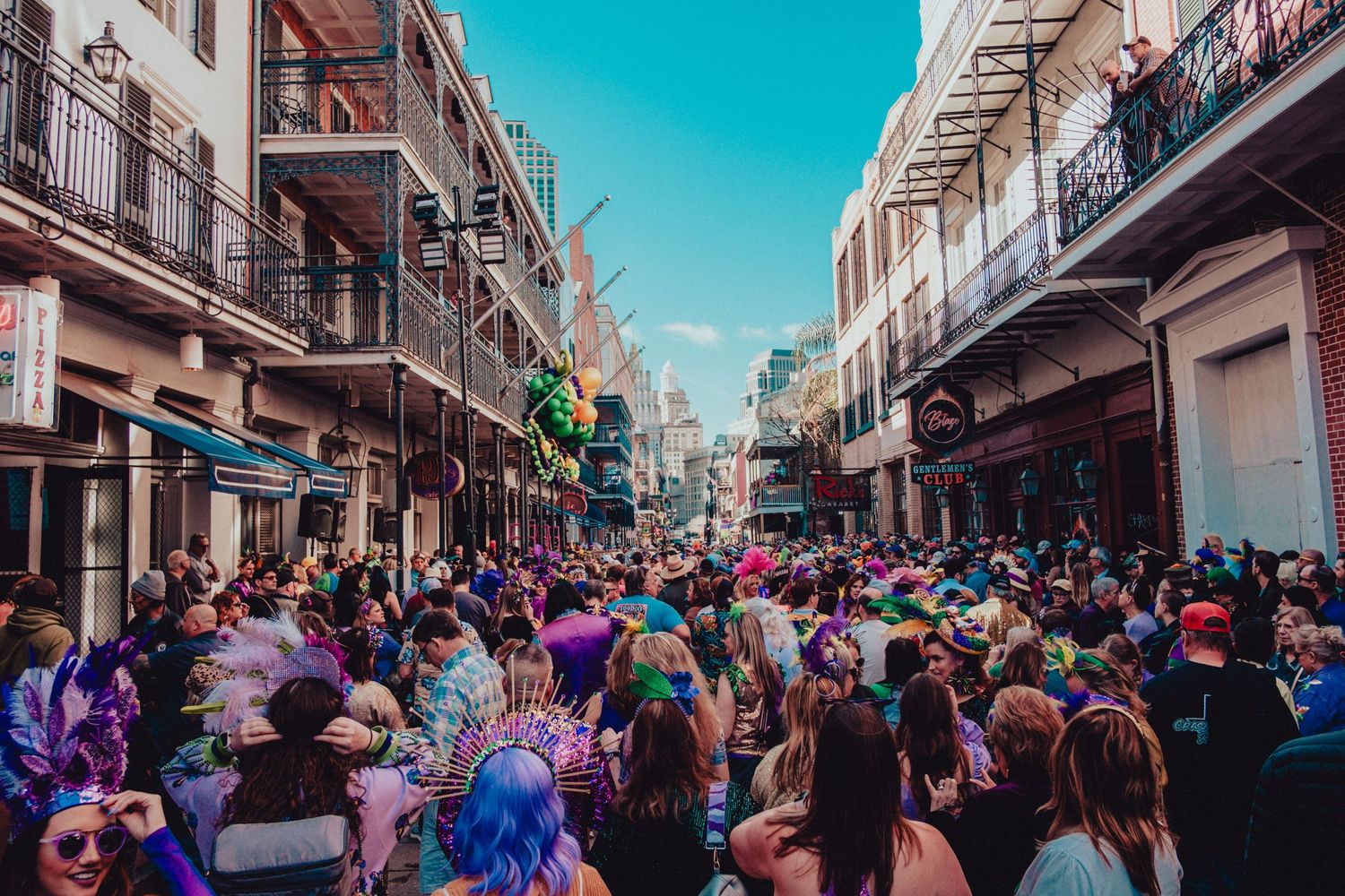 Crowded street scene during festival with colorful crowd and historic buildings.