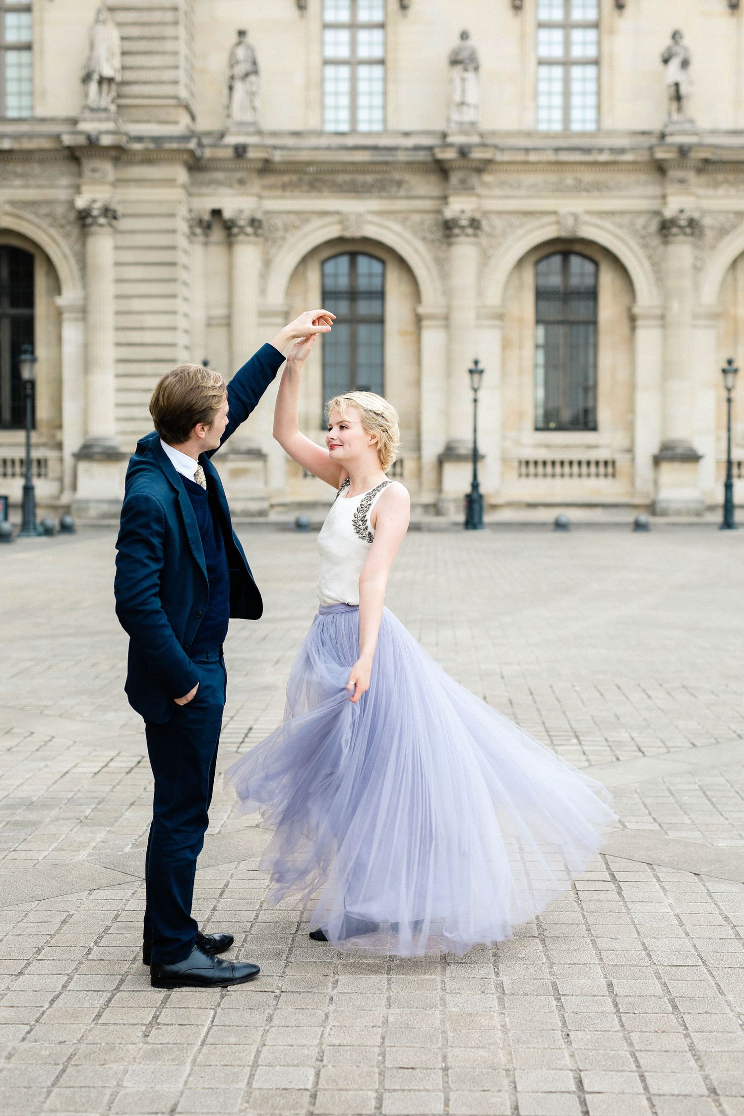 Couple dancing sweetly in the Louvre in Paris in the sunrise for their engagement shoot