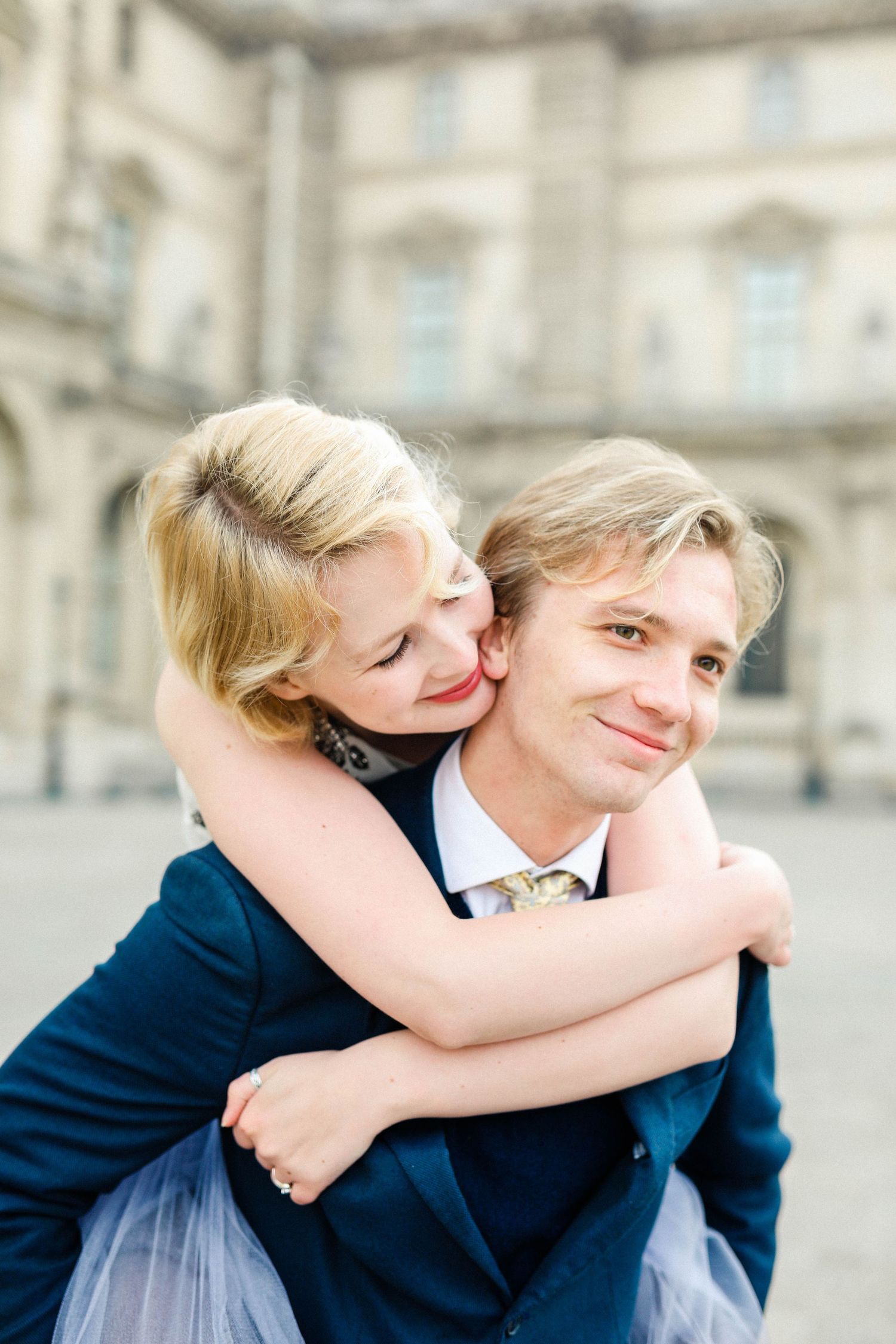 Couple posing in the Louvre in Paris in the sunrise for their engagement shoot