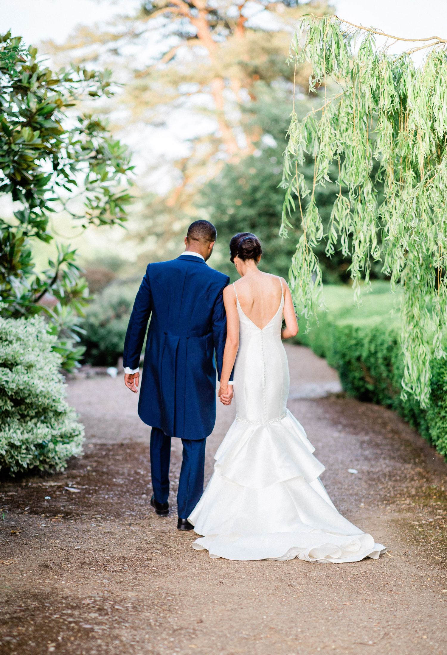 Newlyweds walking away together holding hands during romantic wedding portrait session in Kent wedding venue