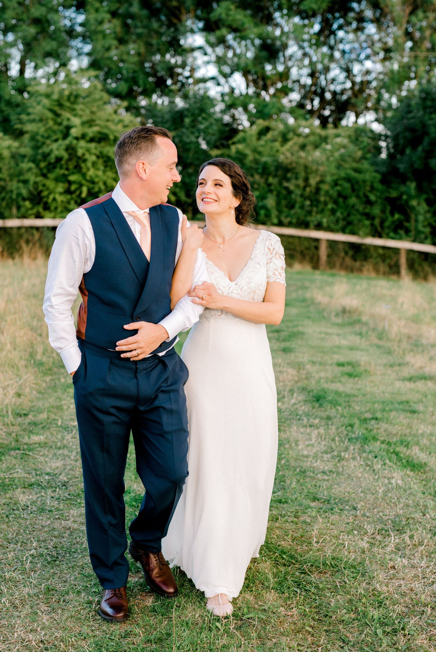 Happy newlyweds walking together smiling for professional wedding portraits after ceremony in London