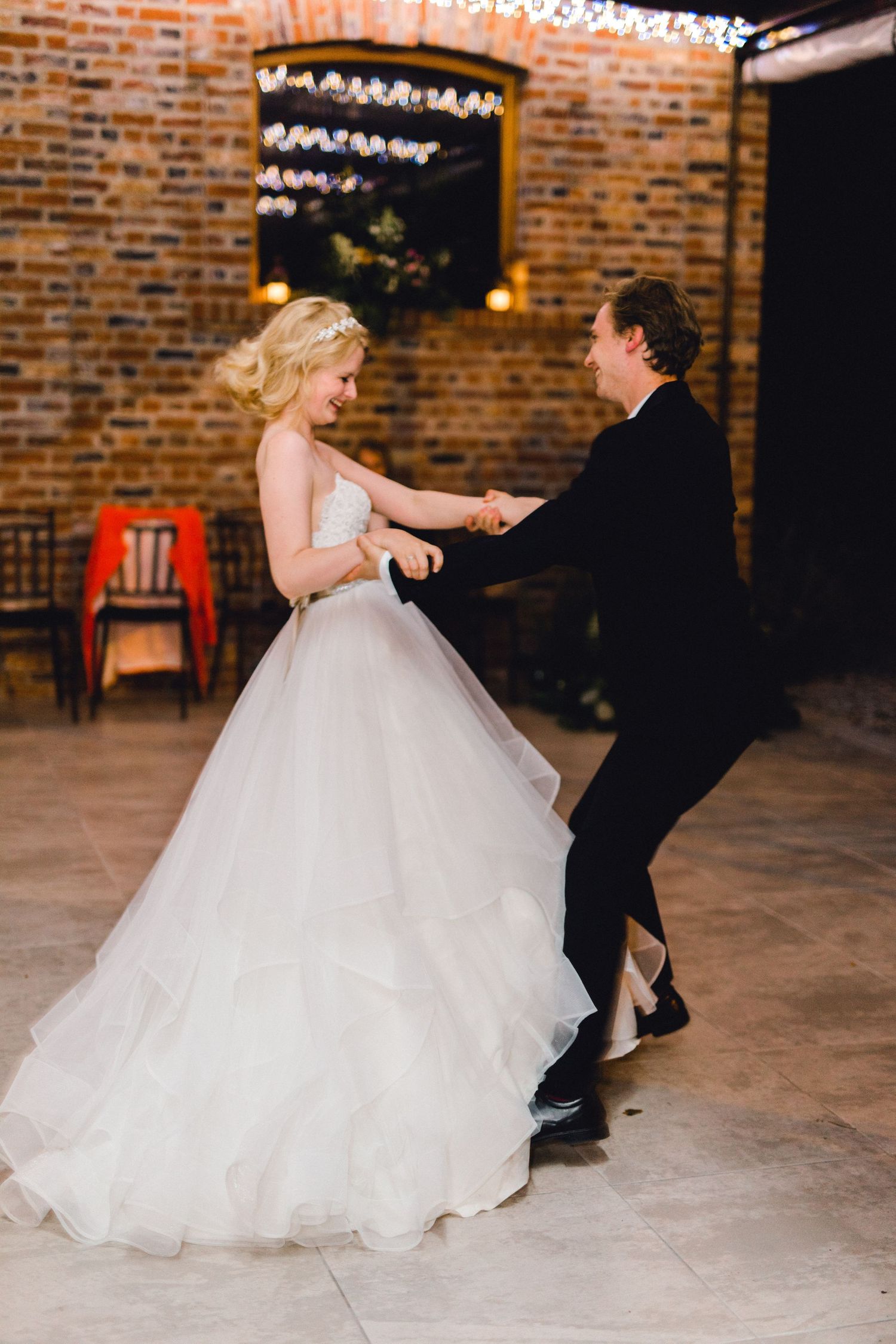 Newlyweds enjoying playful first dance moment with smiles and laughter at wedding