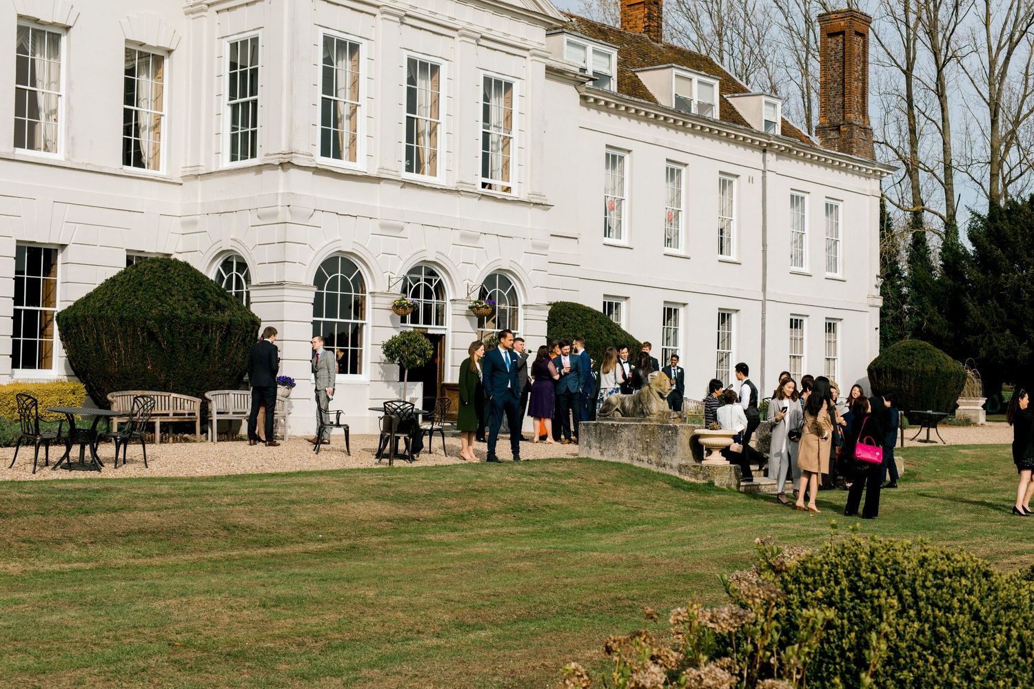 Candid wedding reception photography capturing guests chatting and enjoying celebration in Gosfield Hall Essex