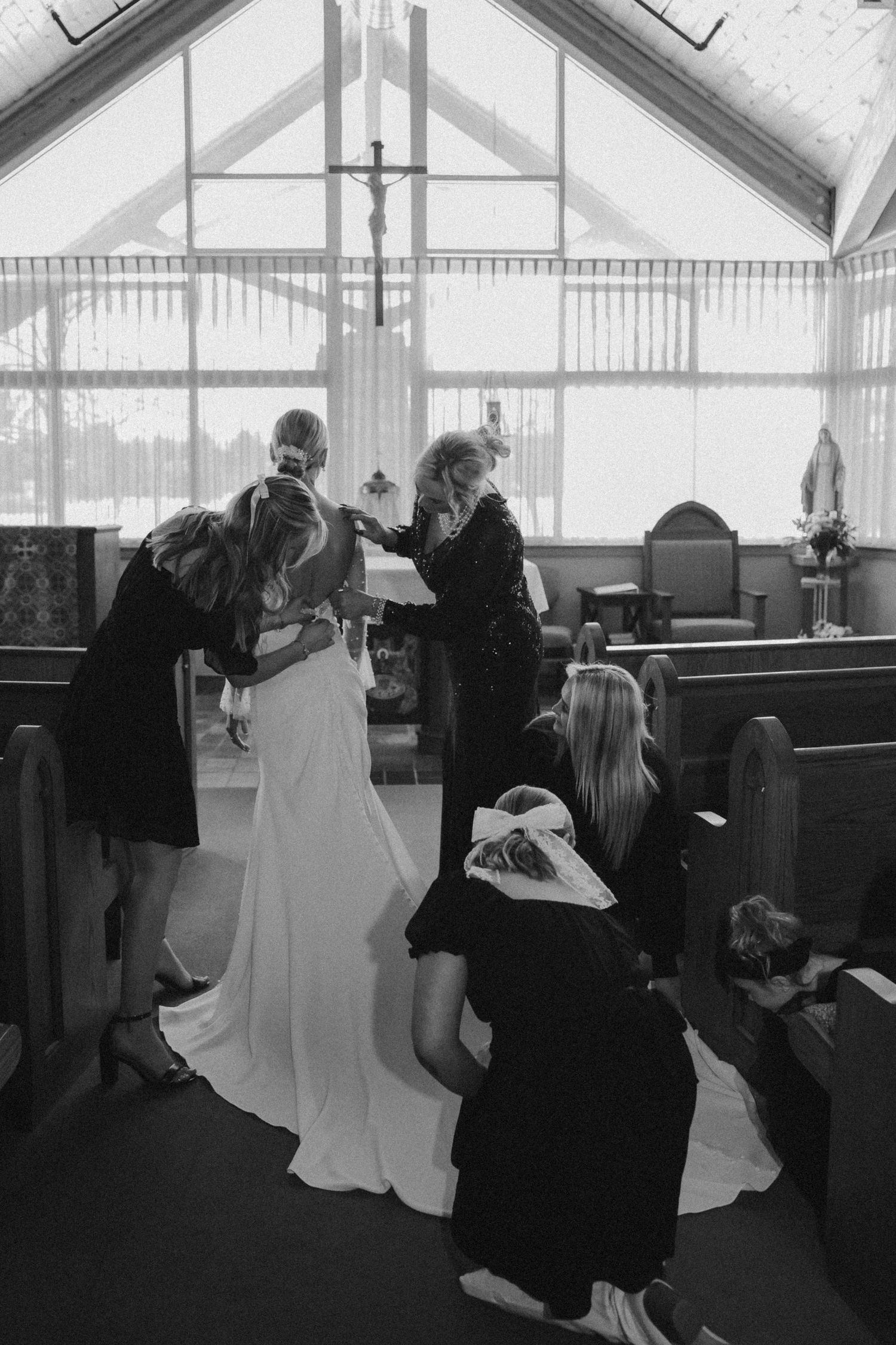 Wedding ceremony preparations inside bright white chapel interior.