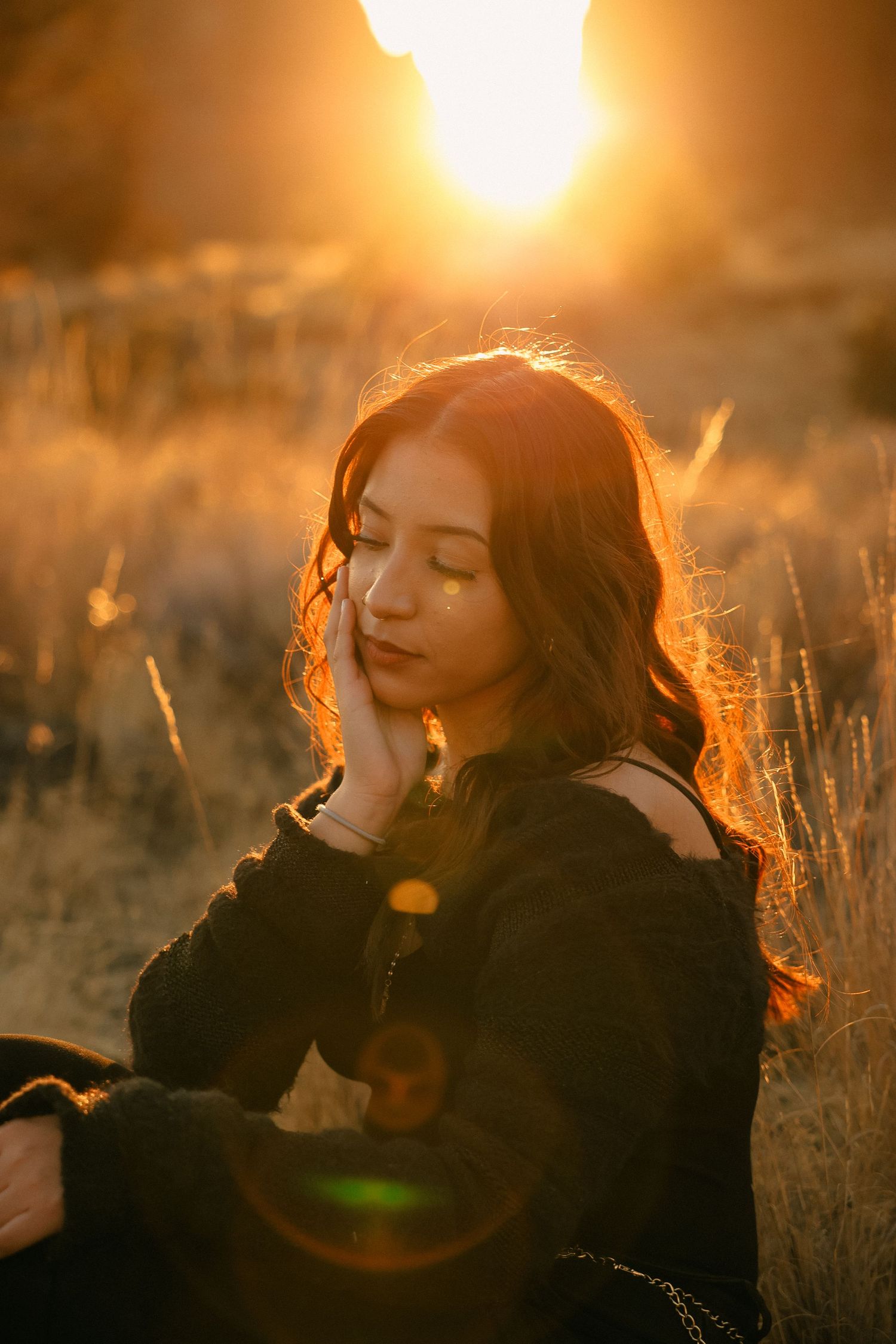 Portrait in golden sunlight with warm backlighting through tall grass at sunset.
