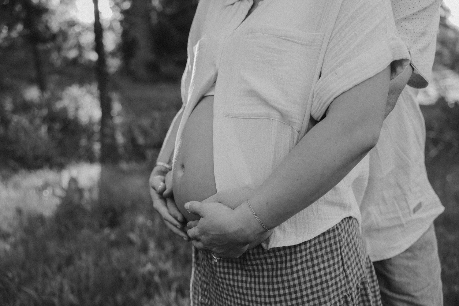 Close-up view of someone wearing white and gingham pattern clothing in natural light.