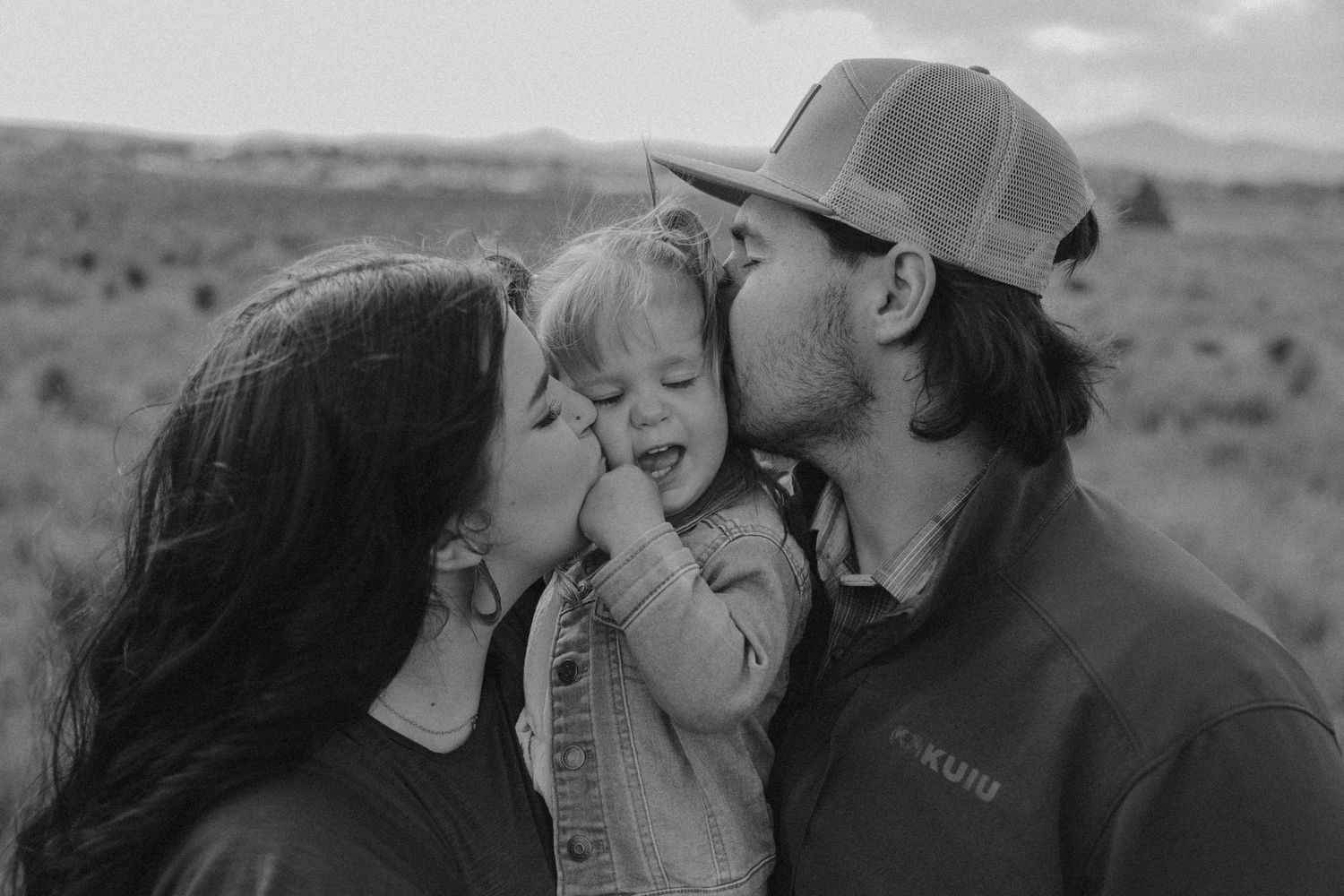 A couple embraces lovingly in a rustic outdoor setting.