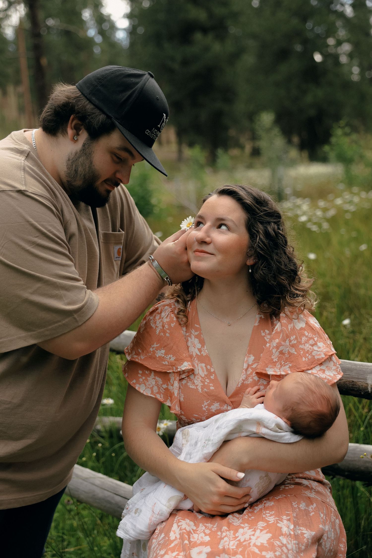 A sweet candid photo series set in a meadow with wildflowers shows tender family moments during breastfeeding.