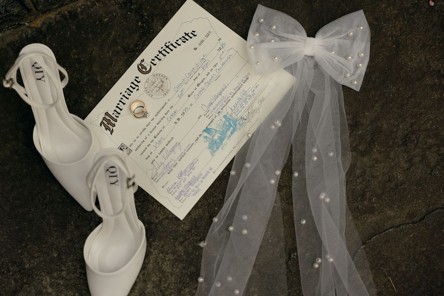 Wedding documents and papers scattered on a dark surface.
