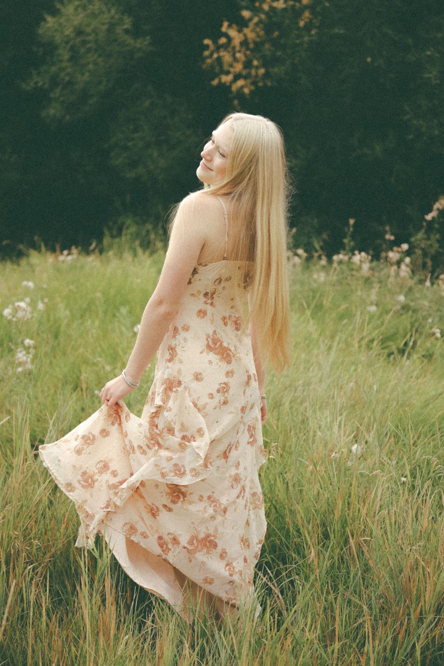 A flowing floral dress twirls gracefully in a summer meadow during a dreamy outdoor photoshoot.