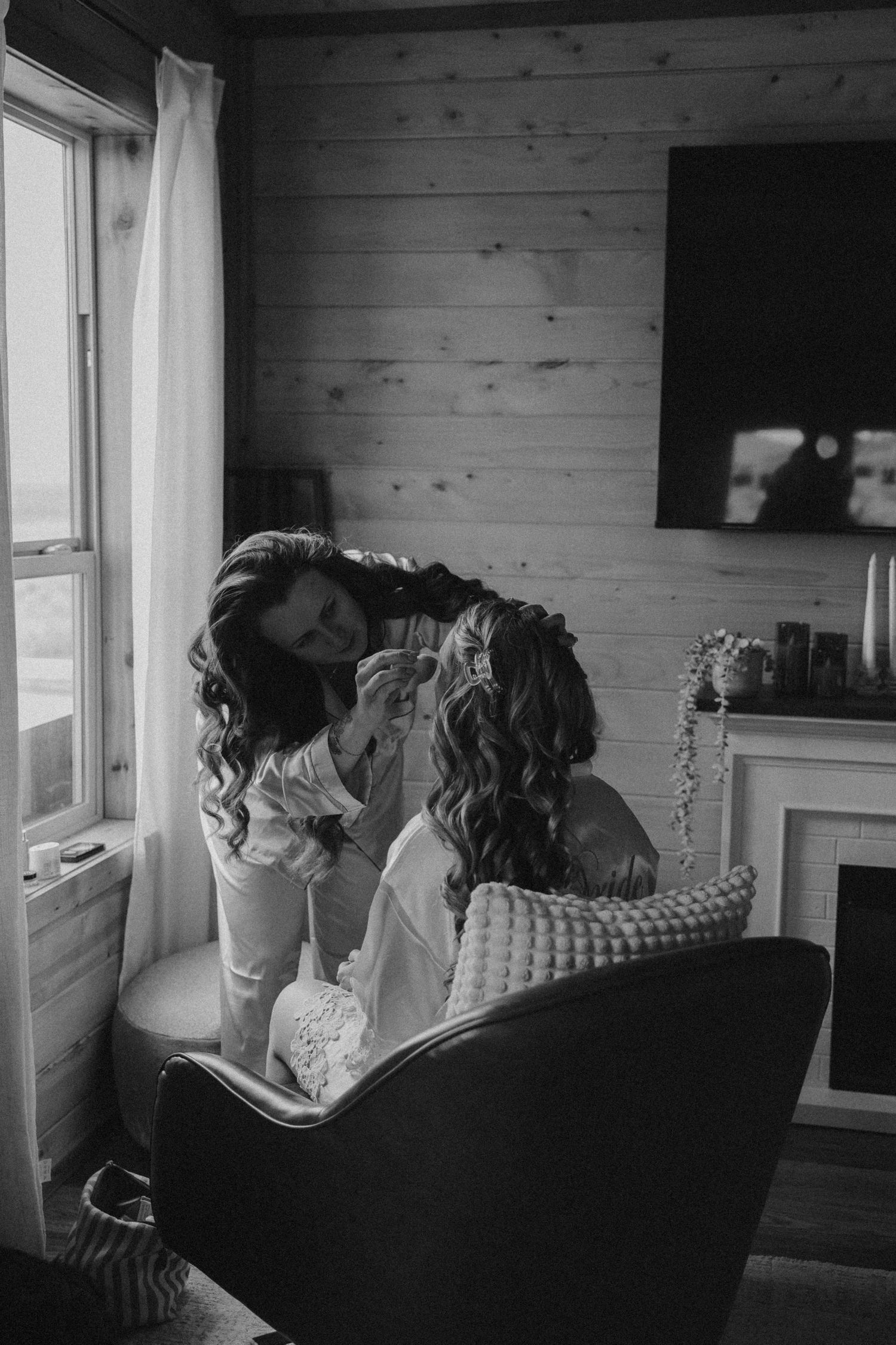 Black and white photo series showing people on a couch looking out through a window in a rustic cabin.