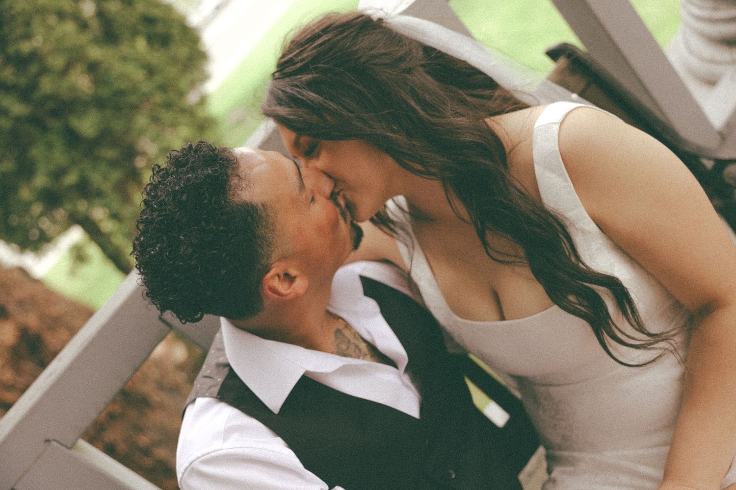 Couple in wedding attire sharing an intimate moment outdoors.