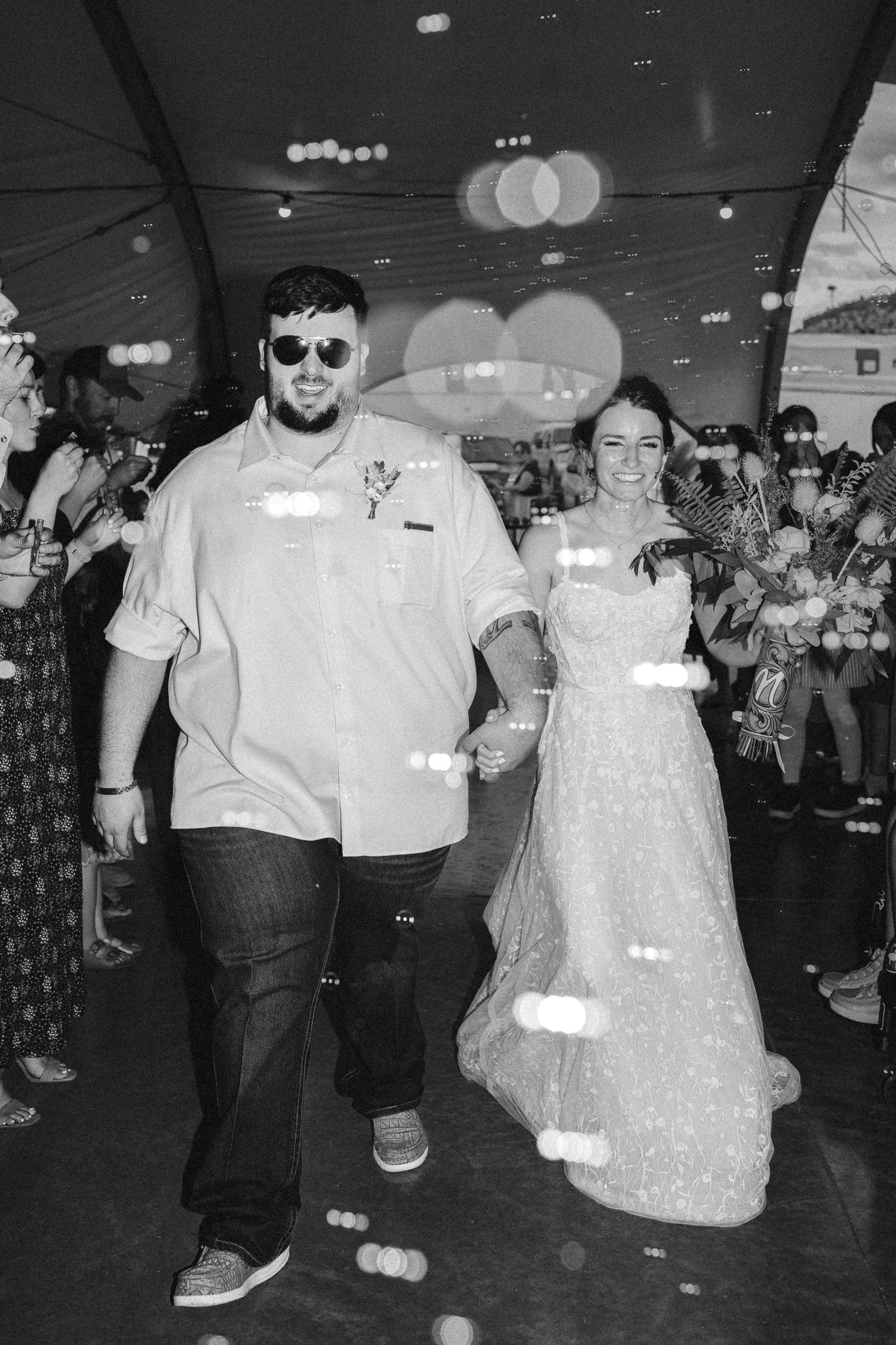 Black and white reception photos showing guests dancing and celebrating at a wedding party.