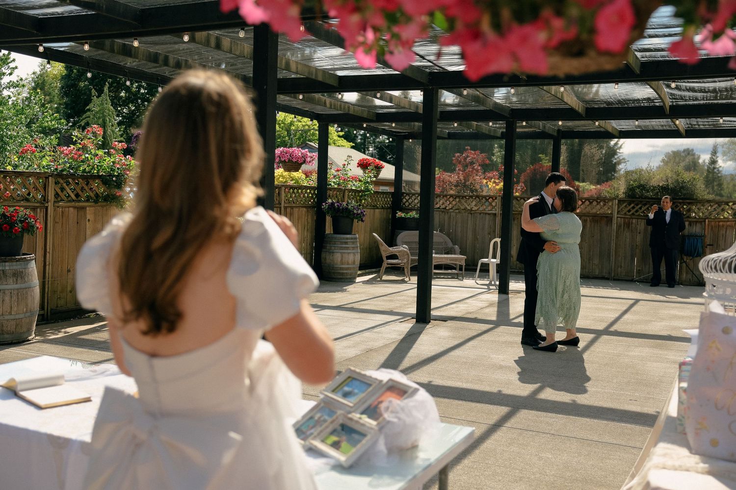 A beautiful outdoor wedding setting with red flowers hanging from above.