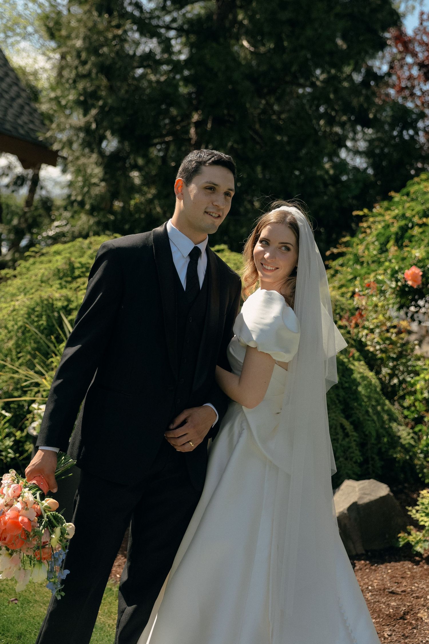 Wedding couple sharing intimate moments in garden setting.