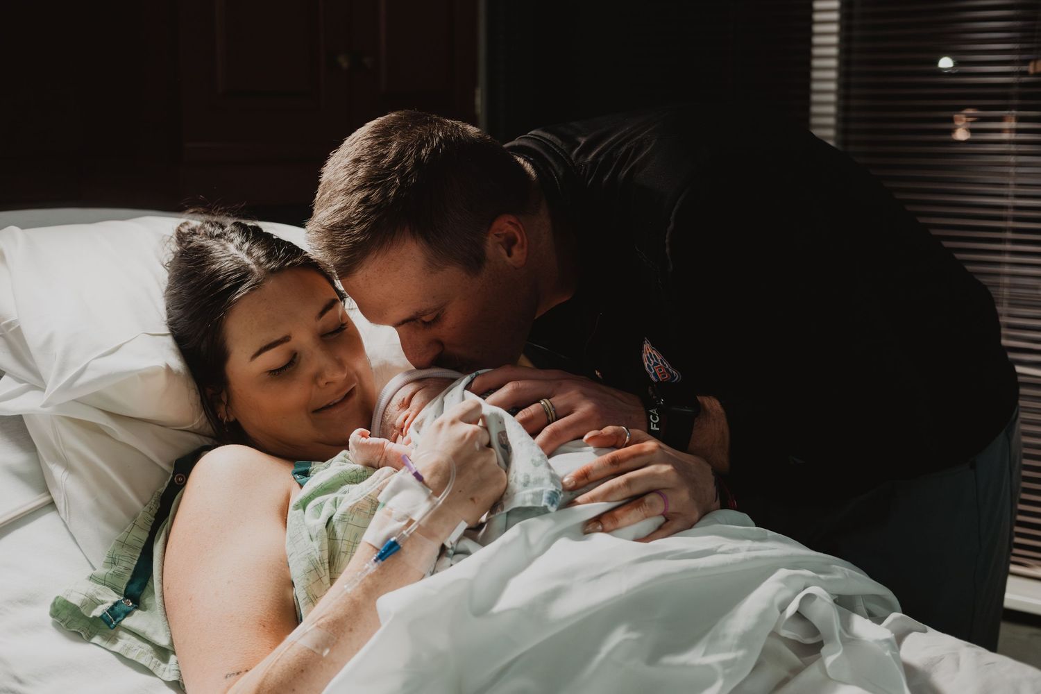 An intimate hospital moment captured as new parents bond with their newborn baby.