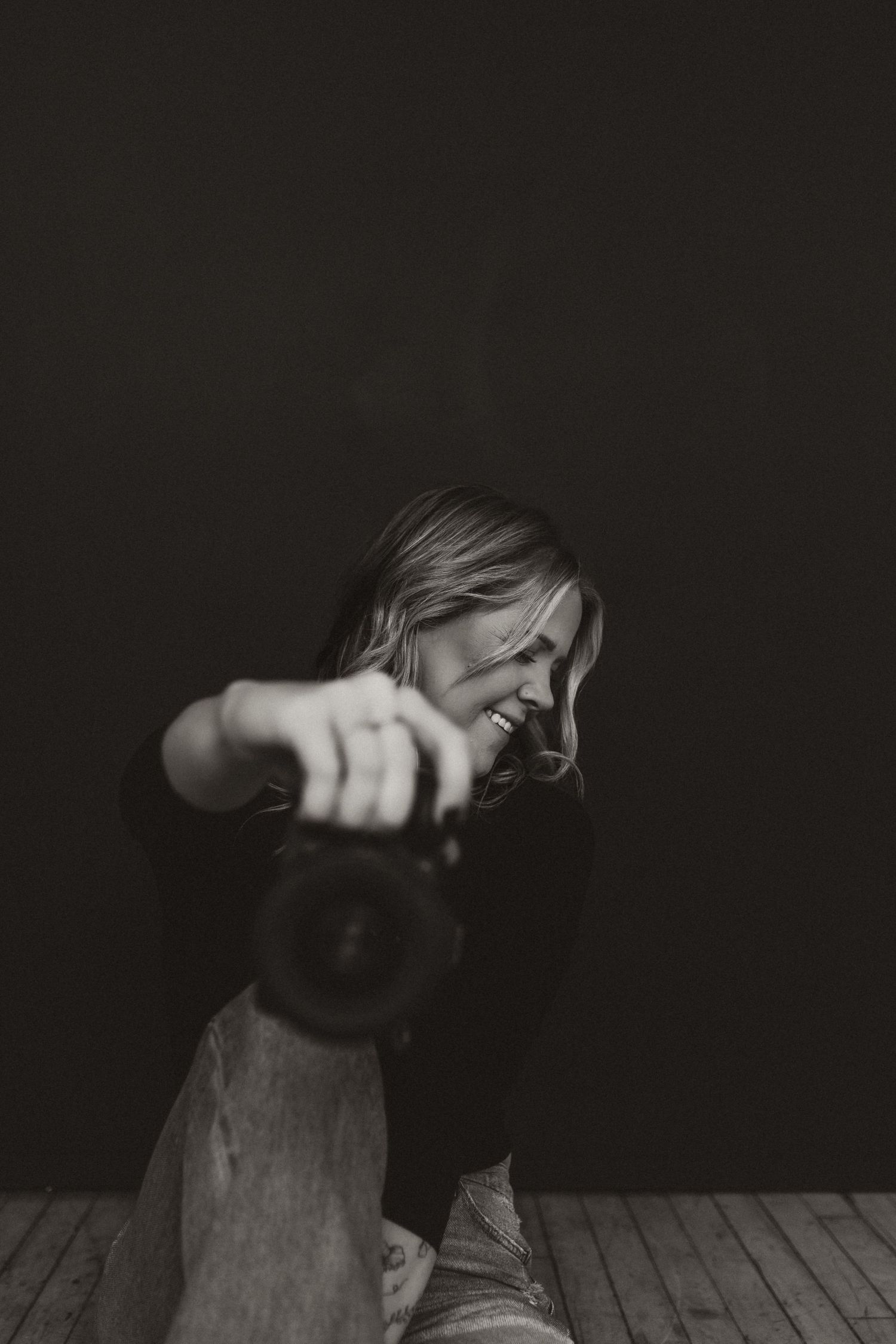 Artistic black and white photo of photographer capturing images in dynamic pose.