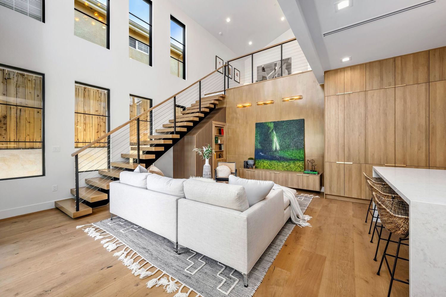 Modern open concept living space with spiral staircase and wood accents.
