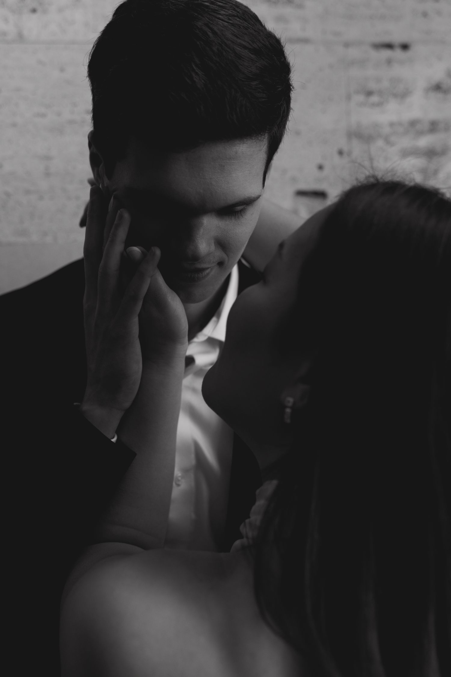 Intimate black and white portrait of a couple sharing a tender moment.