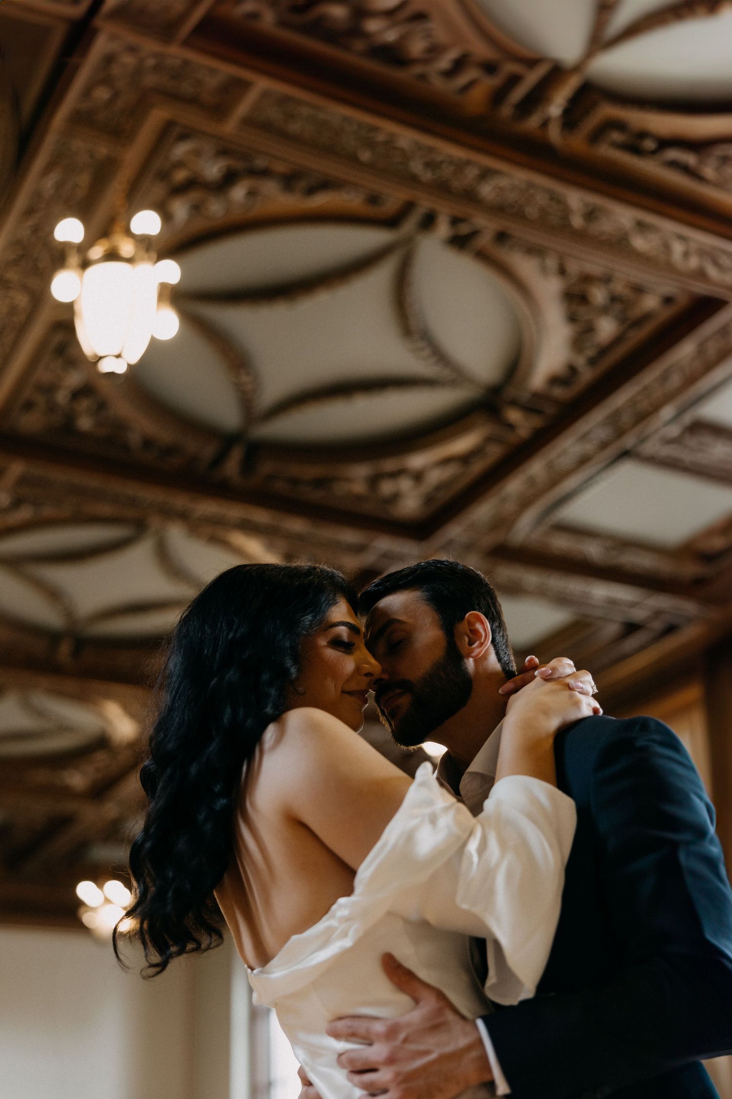 Romantic dance under ornate gilded ceiling with vintage lighting.