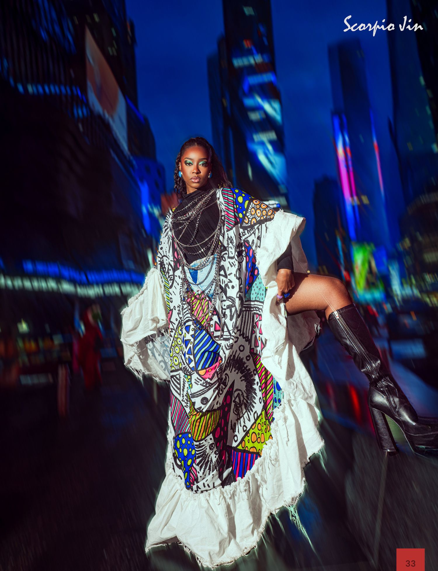 Artful fashion photography in Times Square at night featuring a flowing white dress with colorful patterns and knee-high boots.