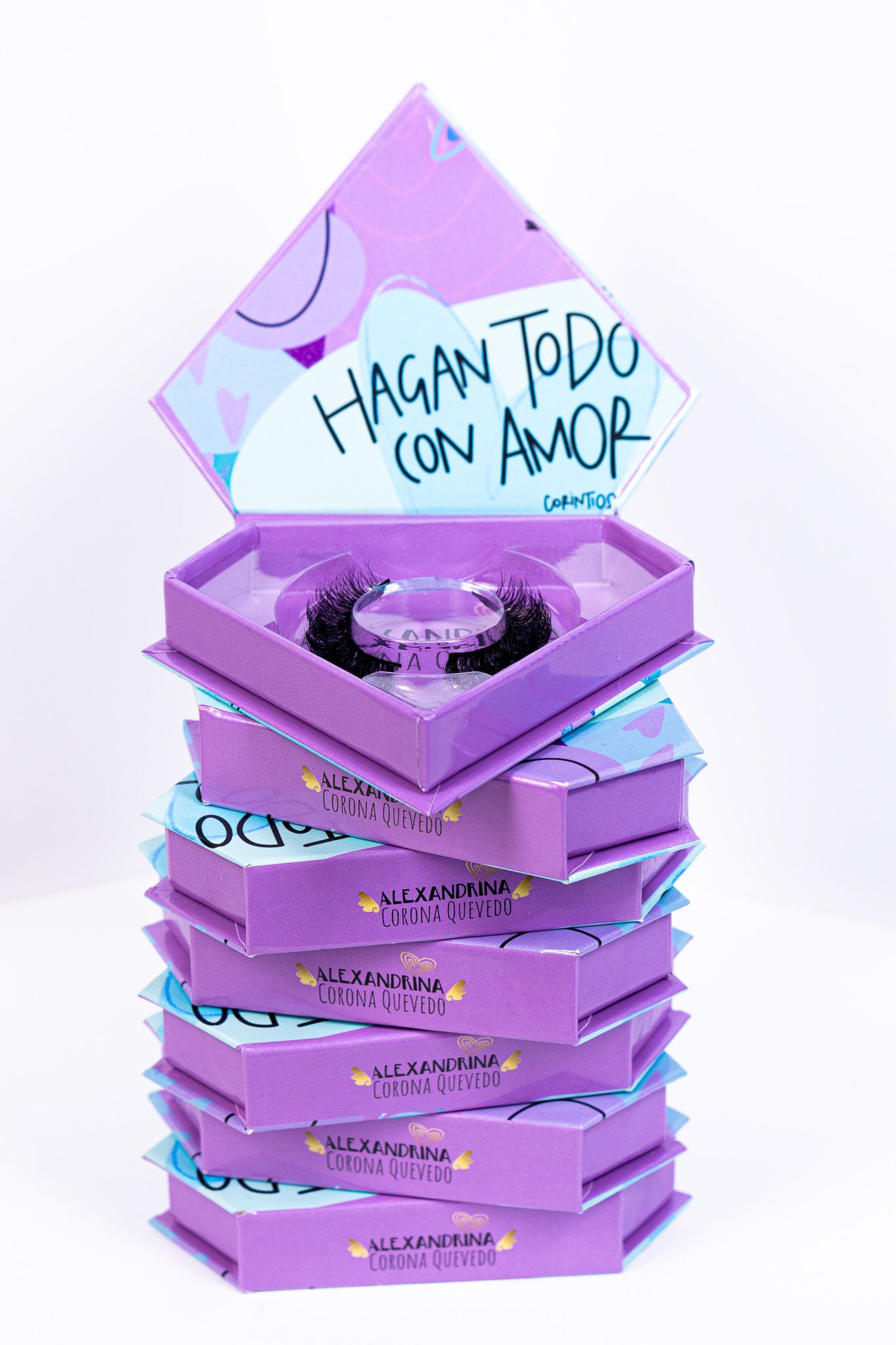 Stack of purple hexagonal pizza boxes with 'Hagan Todo Con Amor' Spanish text and turquoise accents stacked vertically.