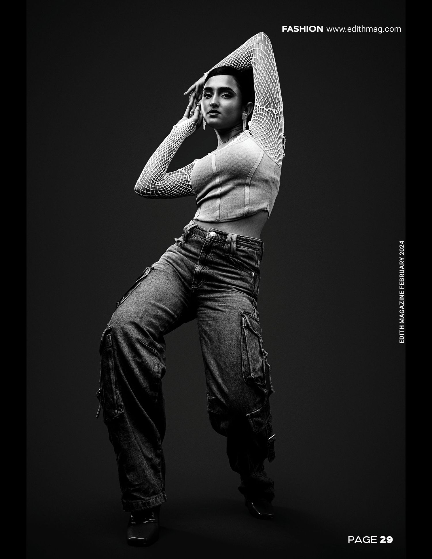 Black and white fashion photo showing a figure in a fitted top and cargo pants striking a dramatic dance-like pose.