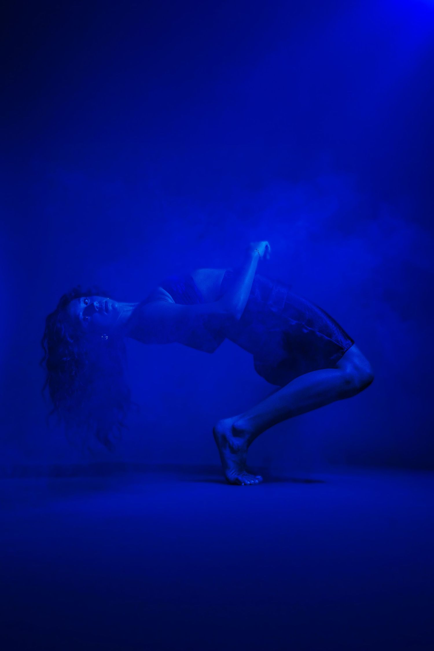 Artistic dance performance captured in deep blue lighting creating a mysterious atmospheric mood. Vacaville Photographer, Dance Photographer