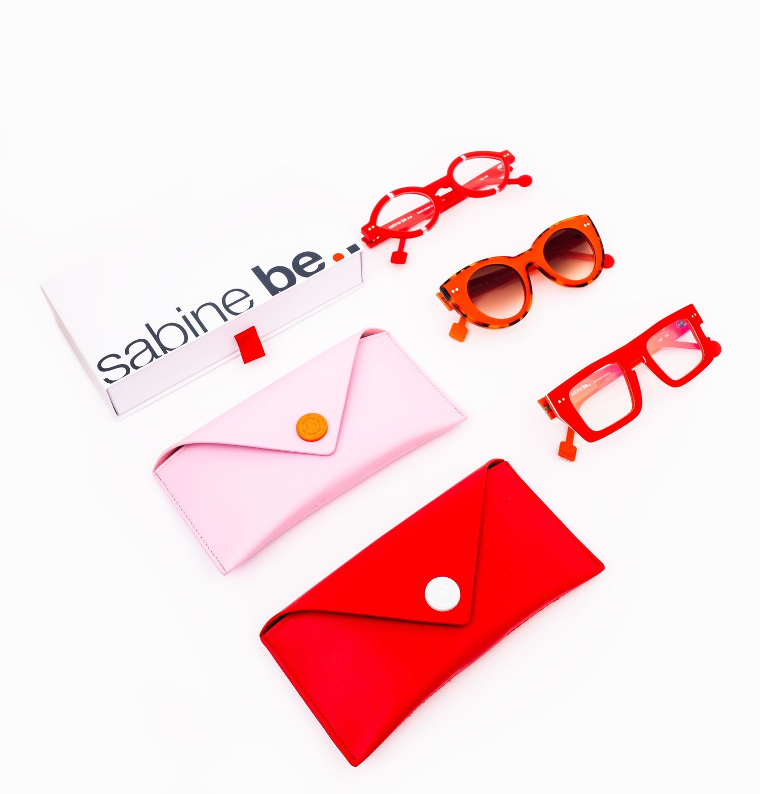 Stylish red and pink sunglasses cases with trendy frames displayed on a white background.