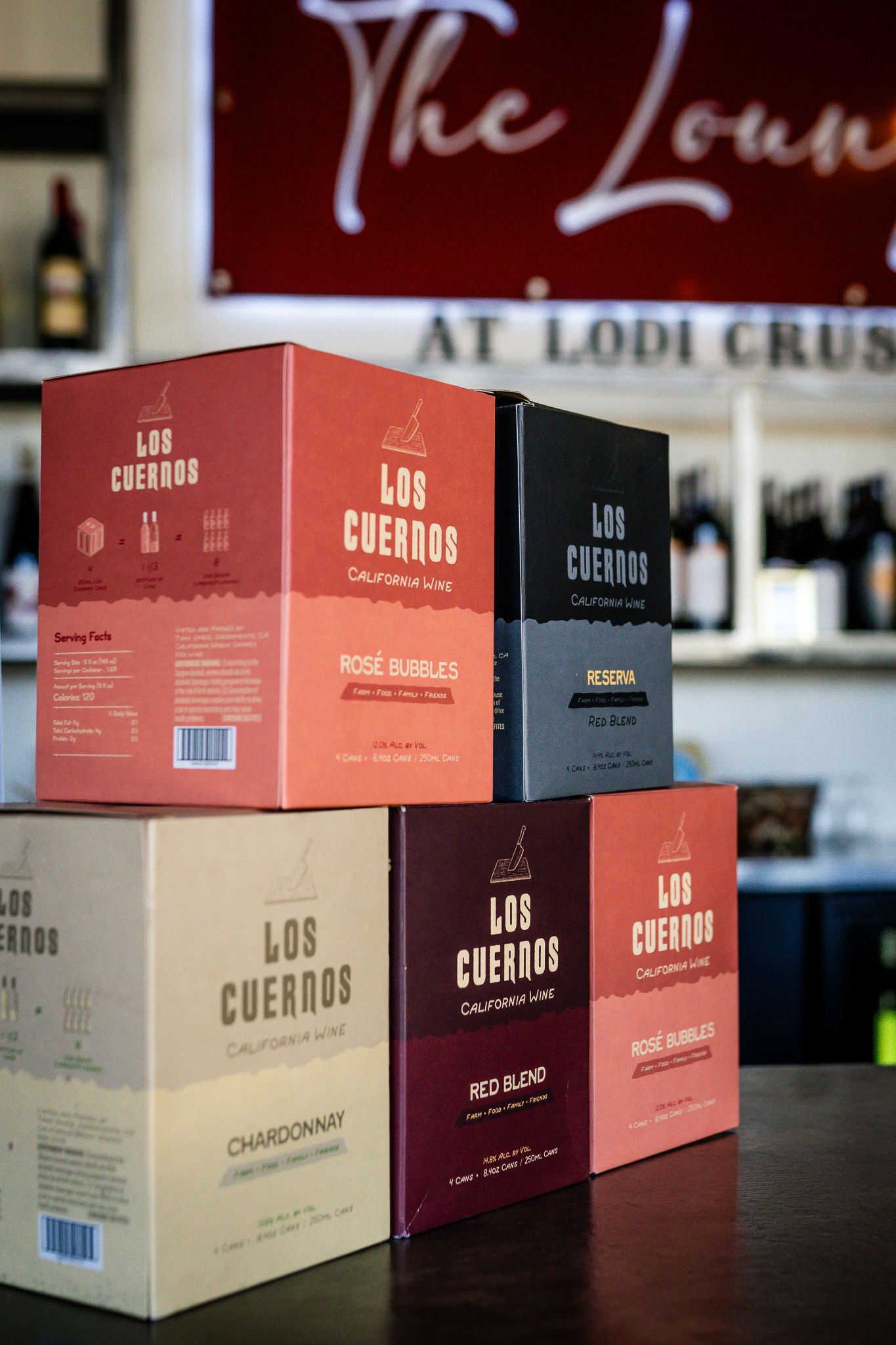 Various wine boxes from Los Cuernos winery brand arranged on display showing different varieties and packaging designs.