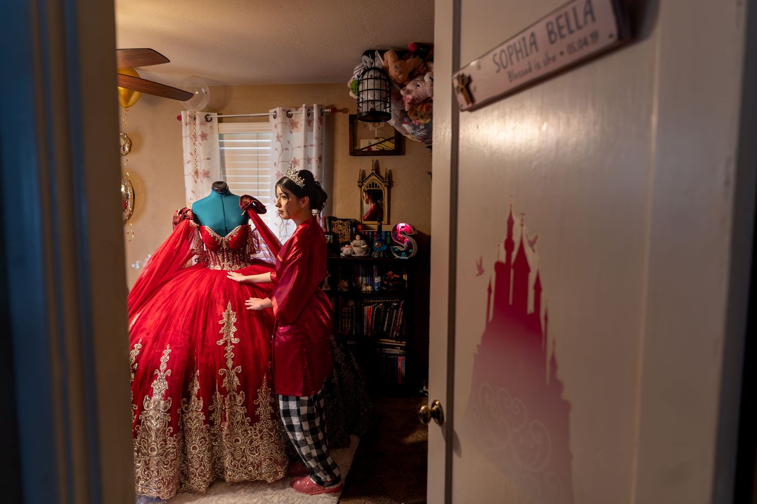 Quinceañera getting ready in red dress, candid prep by The Padillas, Sacramento quinceañera event day photography.