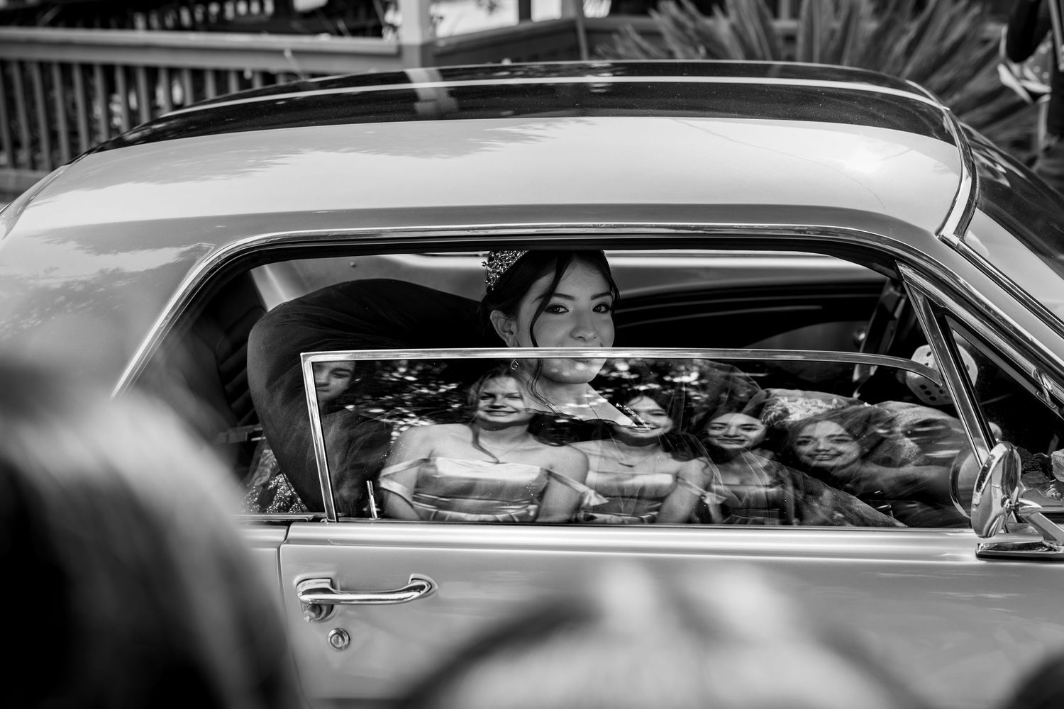 Reflection shot of damas in classic car, black & white documentary quinceañera photo by The Padillas.