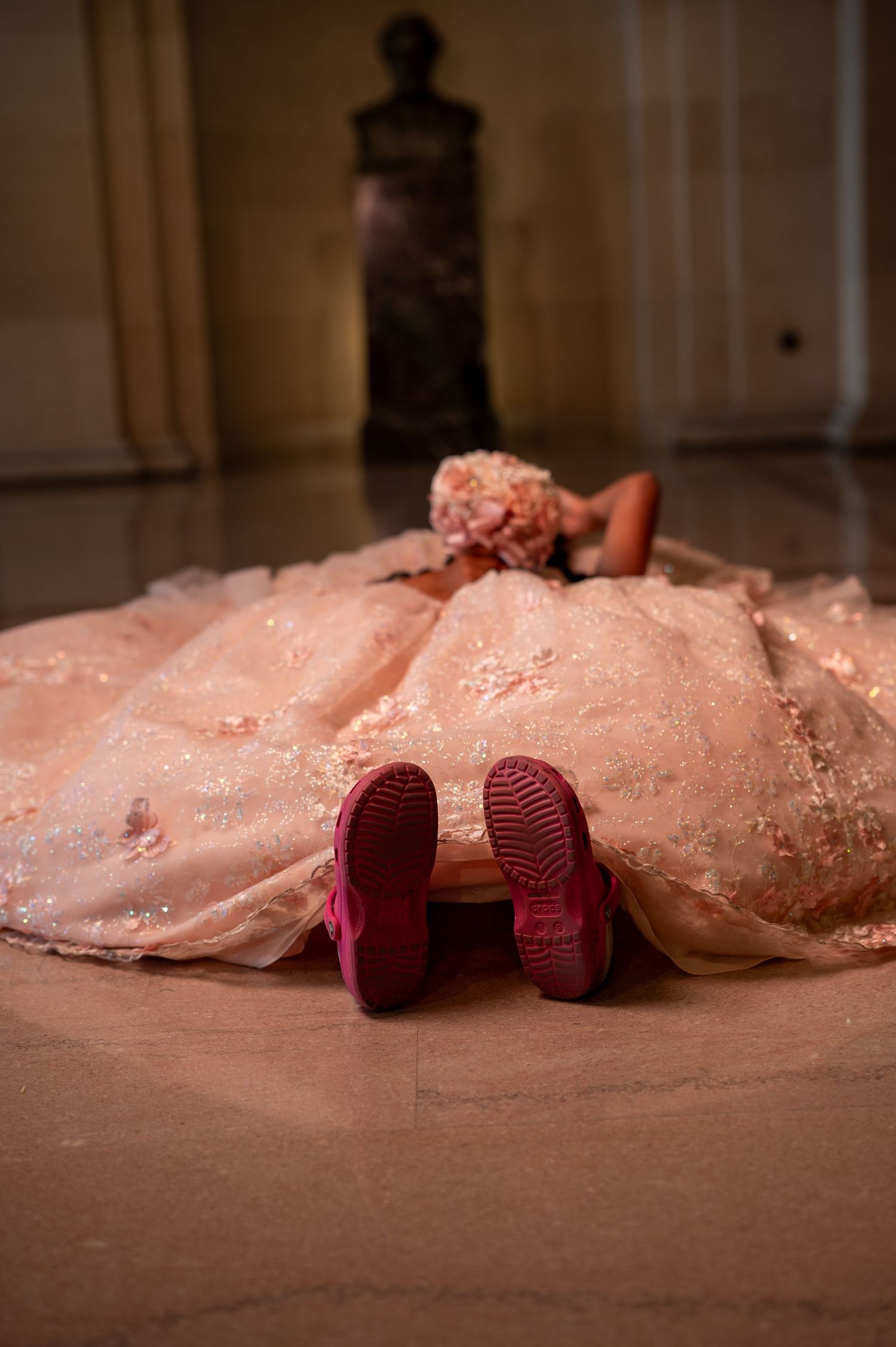 Unique quinceañera pose laying down in pink dress with sneakers at San Francisco City Hall pre-event photoshoot