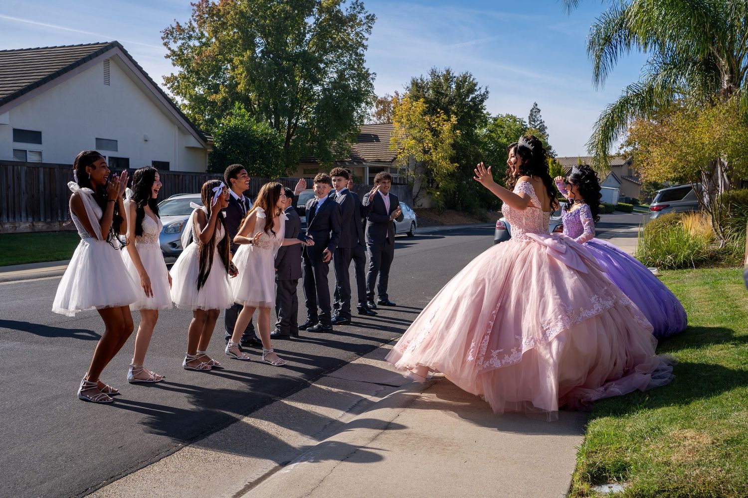 Quinceañera surprise court reveal with damas and chambelanes on residential street Sacramento