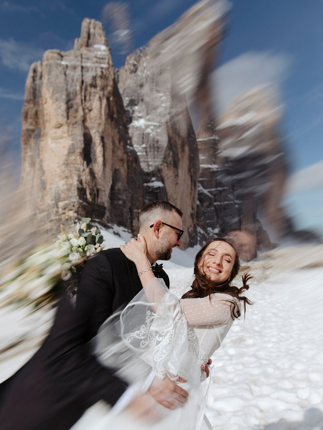 Romantic wedding photo shoot in front of snow-covered Dolomites peaks.