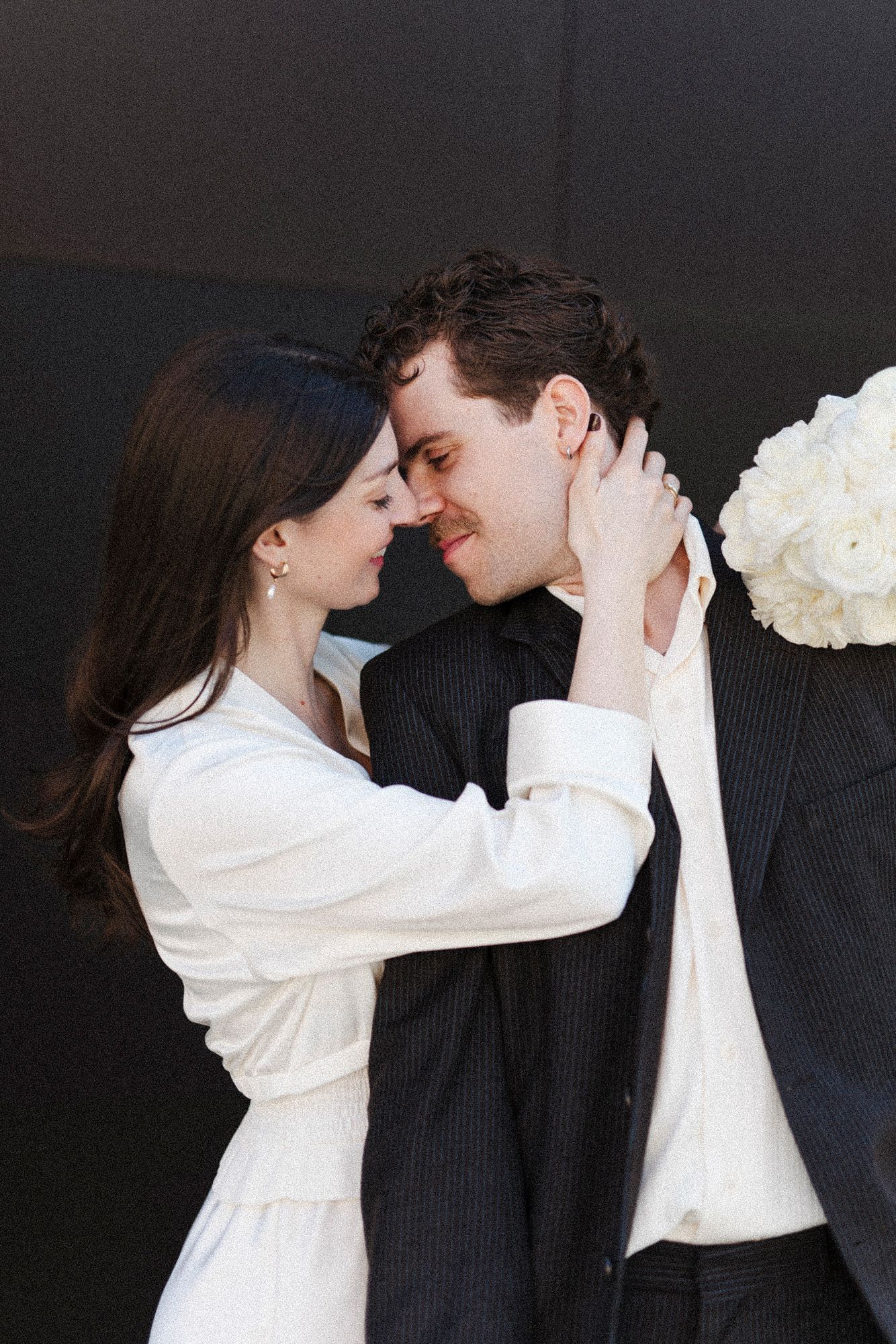Romantic wedding portrait series showing couple in white and black attire with floral bouquet.