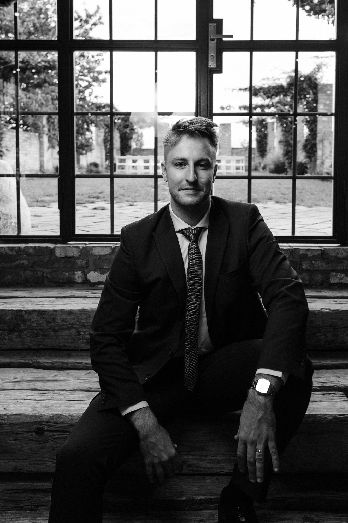 Black and white portrait in industrial window setting.