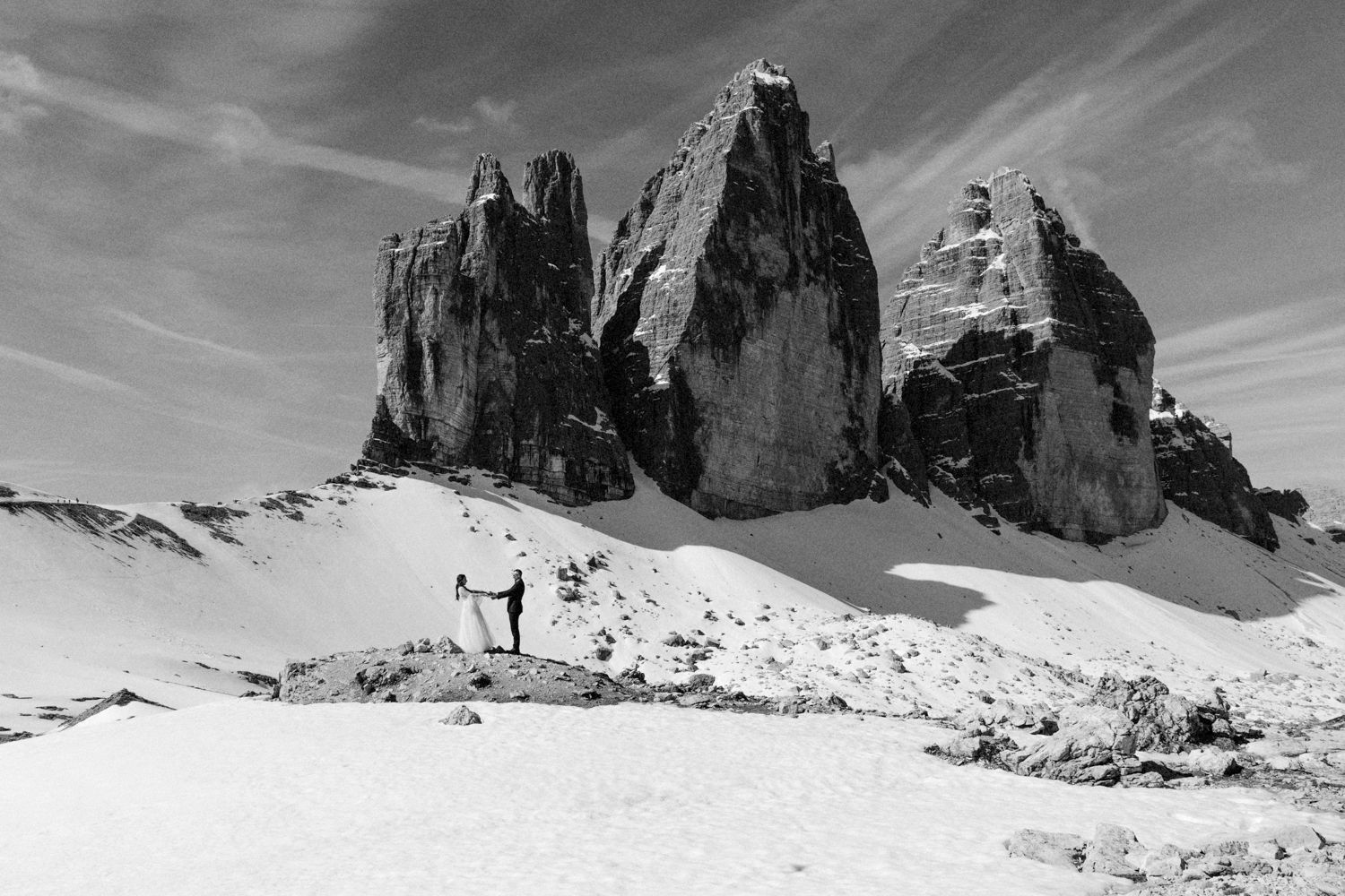 Black and white panoramic landscape of snow-covered mountain peaks in winter.