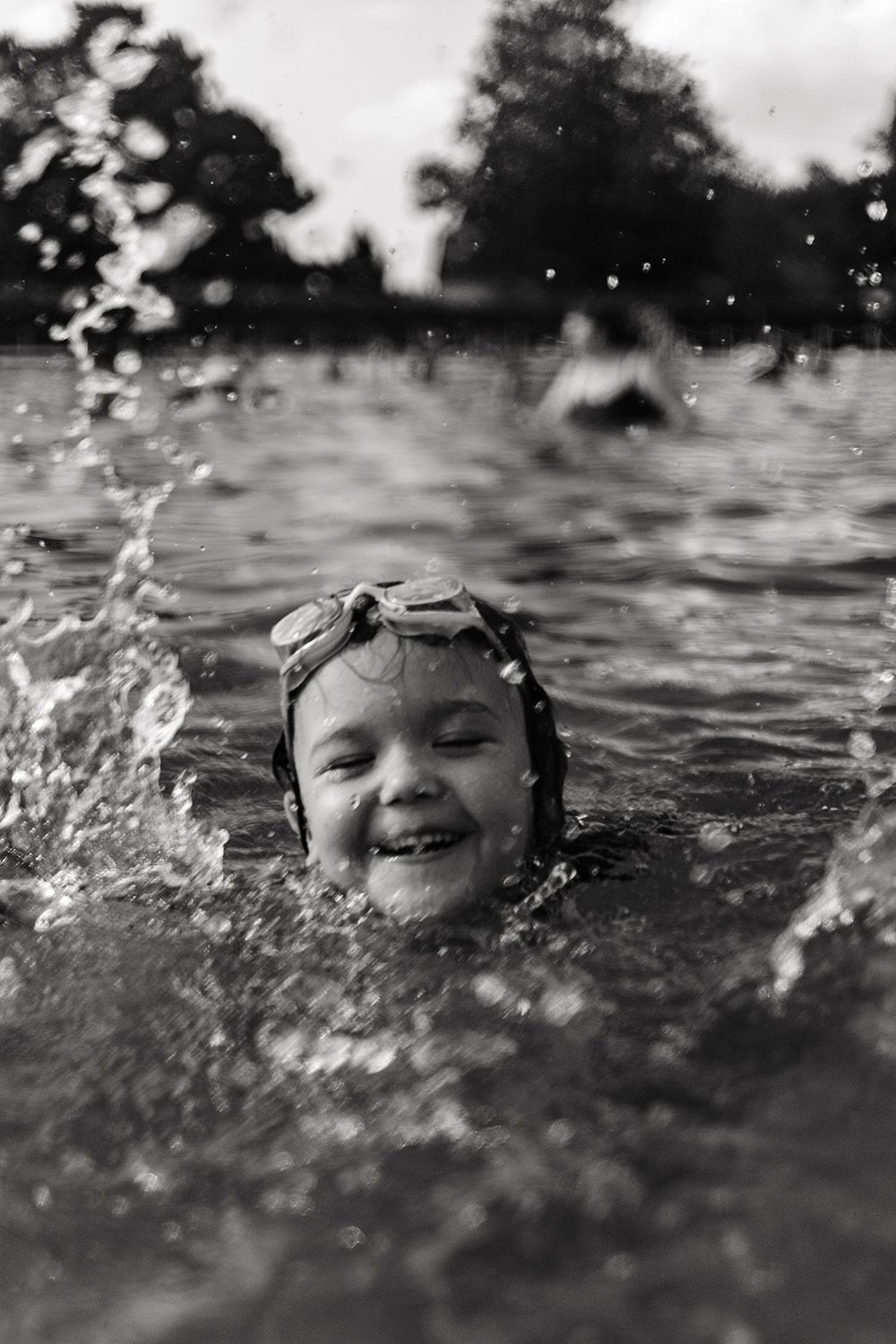 Black and white sequence of joyful swimming moments with water splashes.