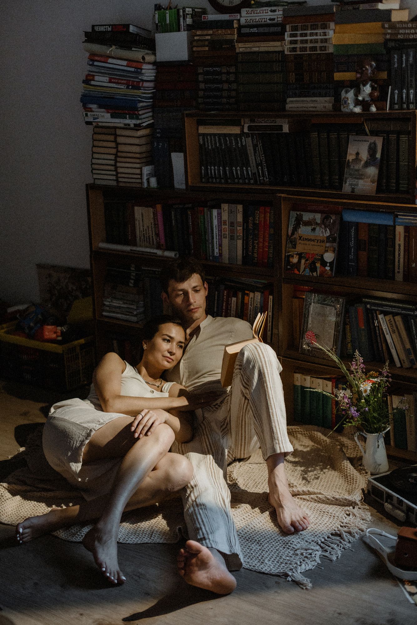 A cozy book reading session on a comfortable couch, surrounded by bookshelves in warm lighting.