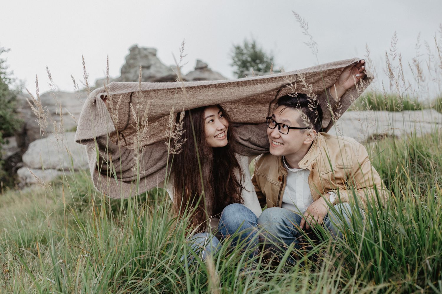 Long grass frames close-up shot of couple relaxing outdoors.