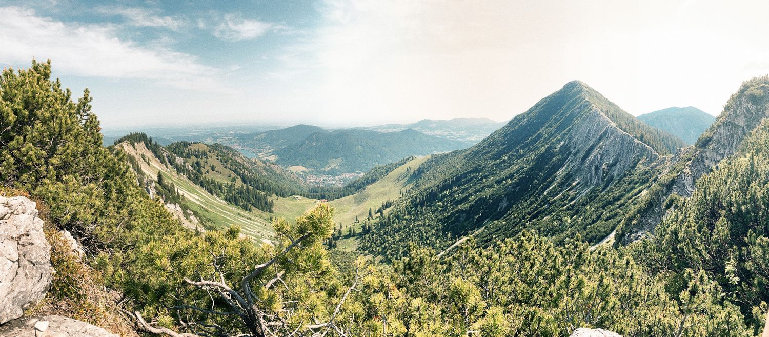 Dramatic mountain vista with deep valleys and forested slopes extending into the distance.