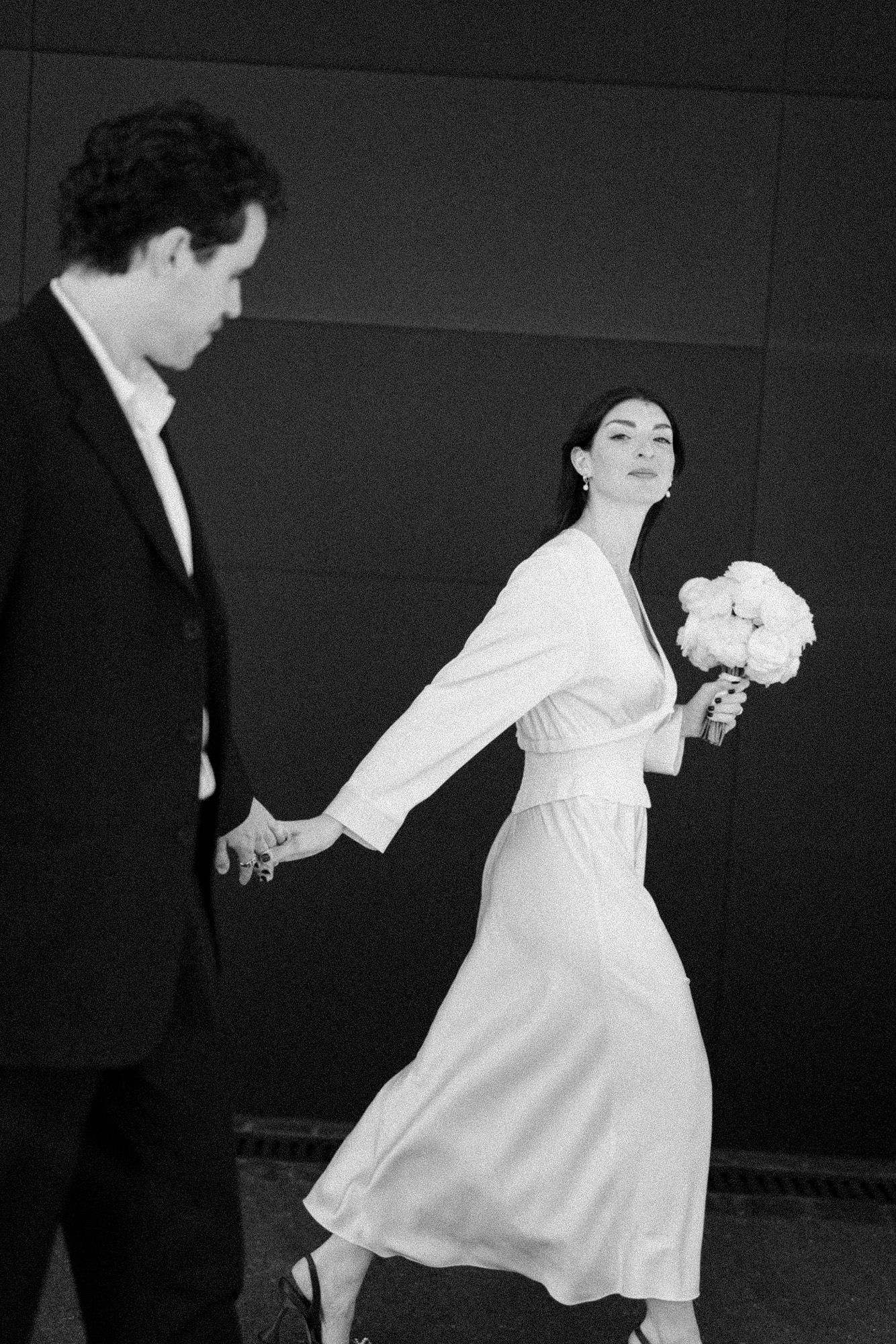 Artistic sequence of dance-like movements in white dress against black background.