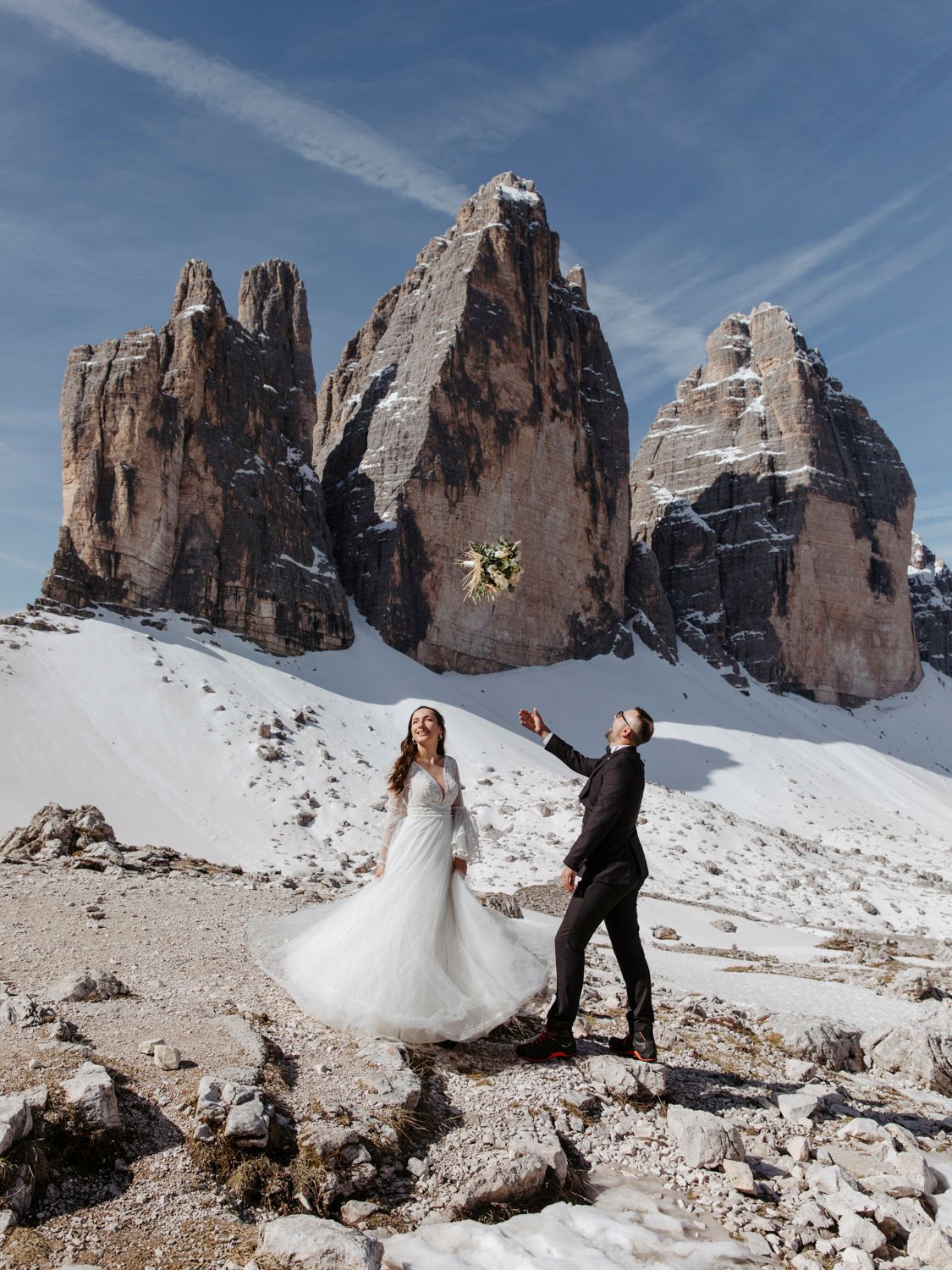 Wedding celebration with flowing dress against dramatic Dolomites mountain scenery.