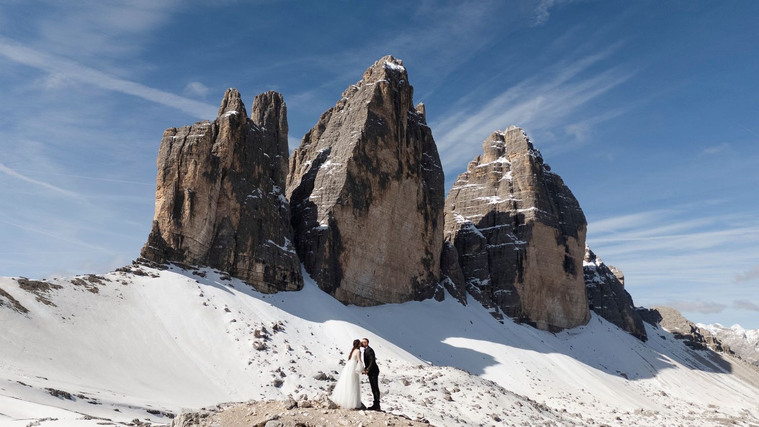 Dramatic mountain peaks rise against a bright blue sky in the Dolomites.