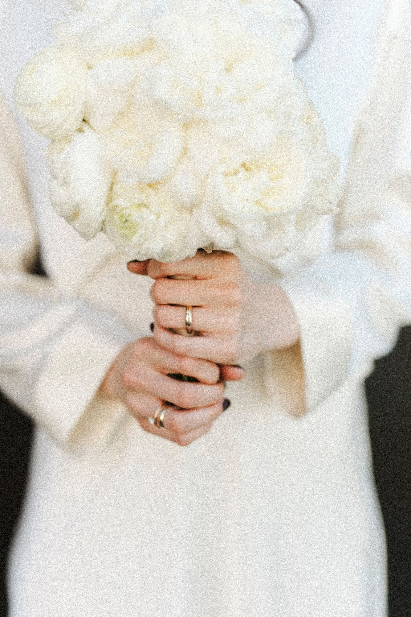 Close-up shots of hands holding white floral bouquet with wedding ring visible.