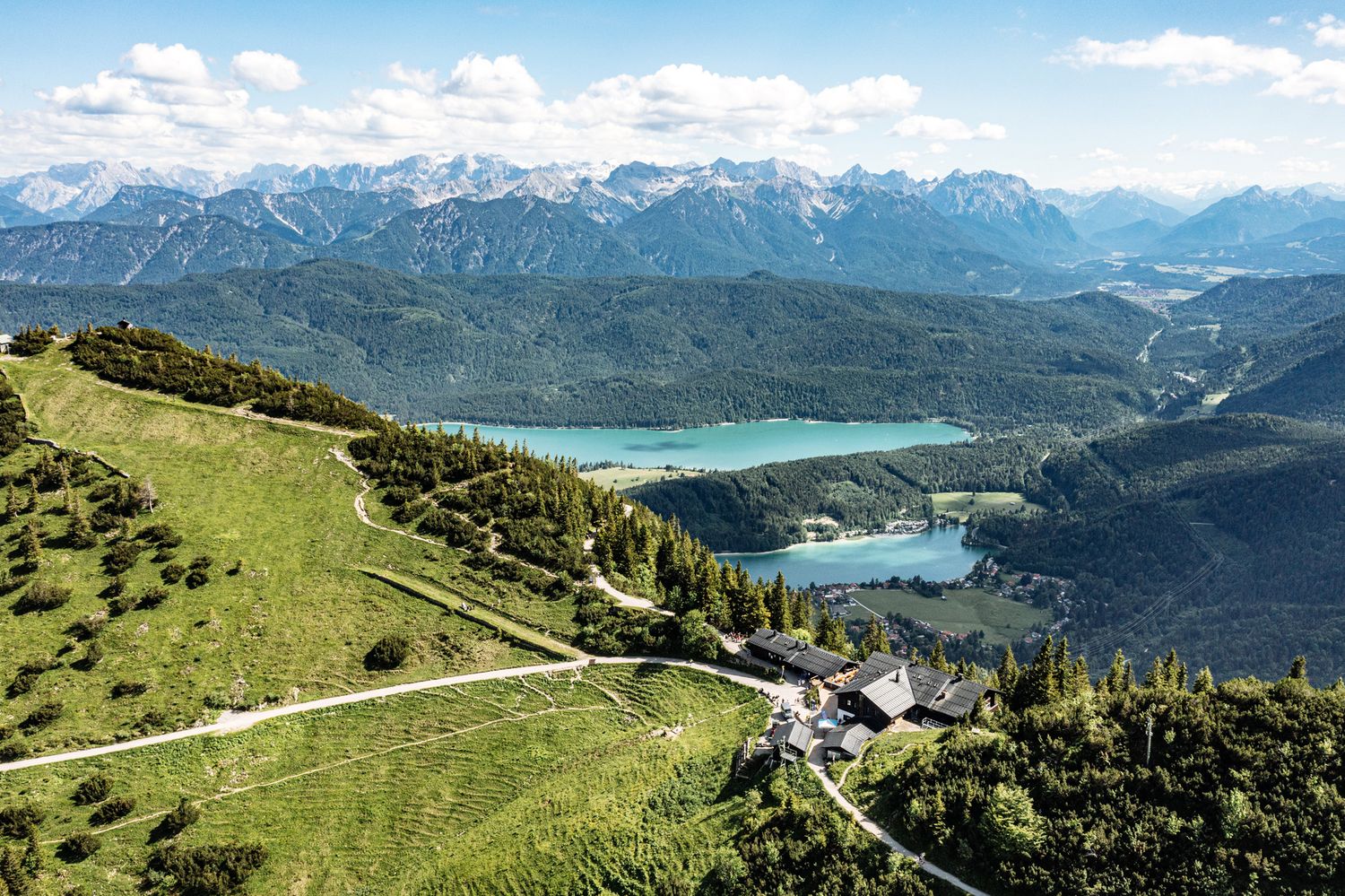Aerial view of mountain landscapes with emerald lakes nestled between forested peaks.